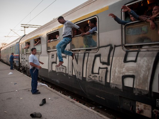 Një emigrant këmbëzbathur hidhet nga një dritare treni në stacion në Gevgelija, Maqedoni Foto: Tsvetomir Dimov