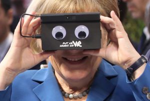 Kancelarja gjermane Angela Merkel teston syzet e realitetit virtual gjatë një turi në Hannover Messe, panairi më i madh në botë për teknologjinë në Hanover të Gjermanisë veriore. E hënë, 25 prill 2016. Foto: BETA/Christian Charisius/AP