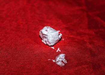 a piece of white powder sitting on top of a red cloth