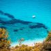 Beautiful turquoise water with a boat and greenery.