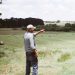 man wearing gray long-sleeved shirt on green grass field