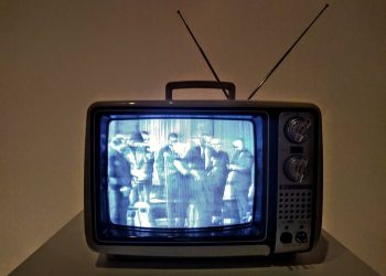 black crt tv turned on on white table