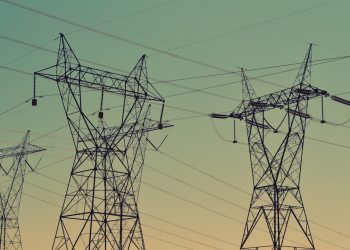 black transmission towers under green sky