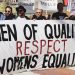 men holding white, black, and red Men of quality respect womens equality banner on road