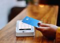a person holding a credit card in front of a machine