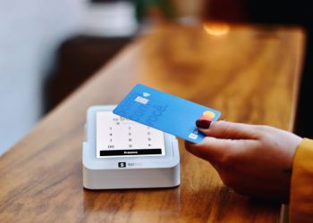 a person holding a credit card in front of a machine