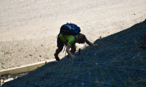 Sindi ngjit rrjetën pranë tunelit në Brar. Tre të pasionuarit pas Rock Climbing tentojnë të ngjisin një shkëmb në Brar. Korrik 2015. Foto: Ivana Dervishi/BIRN.