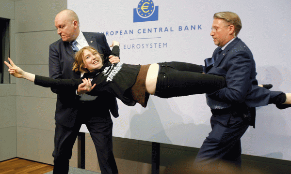 Një aktiviste mbahet peshë për t’u larguar pasi sulmoi presidentin e BQE Mario Draghi gjatë një konference të Bankës Qendrore Europiane në Frankfurt, Gjermani. 15 prill 2015. (AP Photo/Michael Probst)