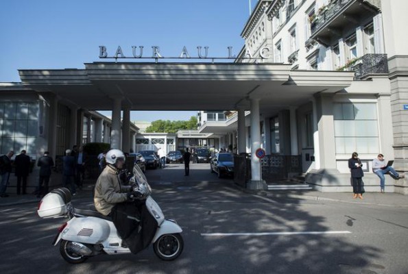 Një burrë nget motorin përpara hotelit me pesë yje Baur au Lac në Zyrih, Zvicër, 27 maj 2015. Gjashtë zyrtarë të futbollit janë arrestuar për korrupsion miliona dollarë. (Ennio Leanza/Keystone via AP)