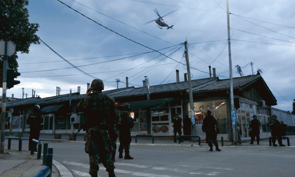 Një helikopter po fluturon mbi një njësi speciale të policisë maqedonase që po largohet nga zona e luftimeve në lagjen e Trimave në Kumanovë më 10 maj 2015. (AP Photo/Visar Kryeziu)