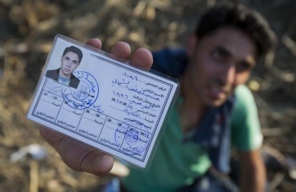 Hussein Al-Shamali, 20 vjeç, nga Idlib, Siri, tregon kartën e tij të identitetit të shkollës teksa kalon kufirin Serbi-Hungari. (AP Photo/Darko Bandic)