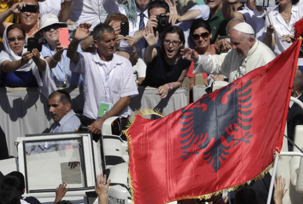 Pope Francis passes in front an Albanian flag as he is driven through the crowd at the end of a canonization ceremony in St. Peter's Square at the Vatican, Sunday, Sept. 4, 2016. Francis declared Mother Teresa a saint on Sunday, praising the tiny nun for having taken in society's most unwanted and for having shamed world leaders for the "crimes of poverty they themselves created." (AP Photo/Alessandra Tarantino)