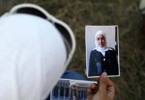 Wafaa Bukai, 25 vjeçe, studente nga Damasku, Siri, mban fotografitë teksa pret për të vëllain të kalojë kufirin nga Serbia në Hungari. Ndryshe nga të tjerët që preferojnë mënyrat elektronike të ruajtjes së fotove, ajo tregon albumin fotografik të fëmijërisë. (AP Photo/Darko Vojinovic)