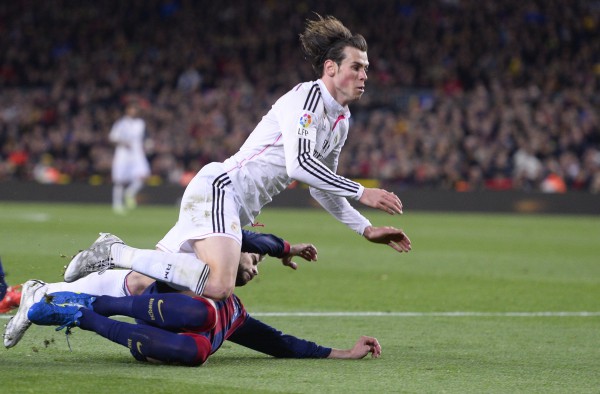 Gareth Bale i Real Madridit bie mbi Gerard Pique të Barcelonës gjatë një ndeshje futbolli të Ligës Spanjolle midis Barcelonës dhe Real Madrid në stadiumin Camp Nou, Barcelonë, SPanjë, 22 mars 2015. (AP Photo/ Manu Fernandez)