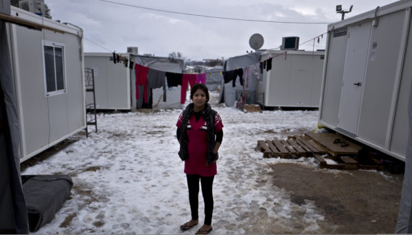Në këtë foto të 11 janarit 2017, Suzan Ahmad, 15-vjeçe dhe 5 muajshe shtatzënë, një refugjate siriane nga al-Hasaka, pozon për një foto jashtë strehës në kampin e refugjatëve Ritsona, Greqi. “Ne u larguam nga shtëpia jonë në kërkim të një vendi të sigurt. Shpresoj që ndonjë vend europian do të na pranojë dhe nuk do të qëndrojmë në këtë kamp,” tha Rashid. (AP Photo/Muhammed Muheisen)