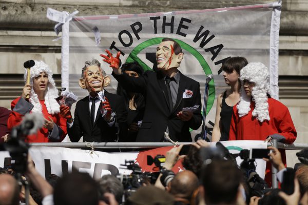 Protestuesit kanë veshur një maskë të ish-kryeministrit britanik Tony Blair dhe ish-presidentit amerikan George Bush ndërsa pozojnë për median në një skenë jashtë Qendrës së Konferencës Mbretëresha Elizabet II në Londër, pak përpara se të publikohej raporti Chilcot mbi luftën në Irak, 6 korrik 2016. Të mërkurën, nëpunësi i shtetit John Chilcot po publikon raportin e tij 2.6 milionë fjalësh mbi luftën dhe pasojat e saj kaotike. Foto: Beta/AP/Matt Dunham