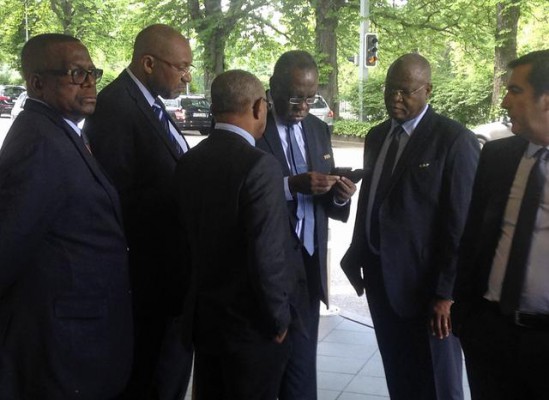Zv.Presidenti i FIFA-s Issa Hayatou nga Kameruni, i treti djathtas, kontrollon celularin jashtë një hoteli në Zvicër. 27 maj 2015. (AP Photo/Graham Dunbar)