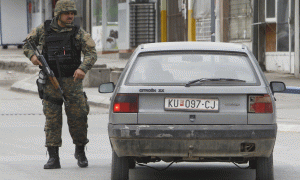 Një polic maqedonas po ndalon një makinë në një zonë ku një operacion masiv policor po zhvillohet në qytetin e Kumanovës më 9 maj 2015. (AP Photo/Boris Grdanoski)