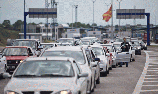 Makinat po kontrollohen në pikën kufitare të Preshevës në kufirin mes Serbisë dhe Maqedonisë ndërsa flamuri maqedonas valëvitet në gjysmështizë. Serbia rriti kontrollet nga frika e përshkallëzimit të situatës. (AP Photo/Marko Drobnjakovic)