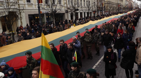Njerëzit mbajnë një flamur gjigant të Lituanisë gjatë festimeve të pavarësisë së shtetit baltik. (AP Photo/Mindaugas Kulbis)