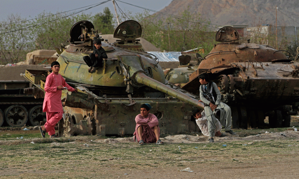 Një fëmijë po luan pranë një tanku të shkatërruar sovjetik në periferi të Kandaharit, Afganistan më 21 shkurt 2015. (AP Photo/Allauddin Khan)