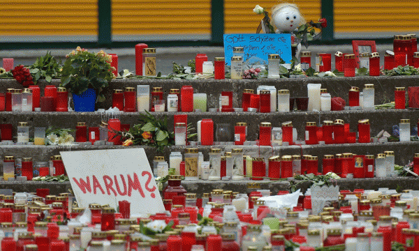 Lule dhe qirinj janë vendosur në një gjimnaz të Gjermanisë pasi mes viktimave ishin 16 nxënës dhe dy mësues. (AP Photo/Martin Meissner)