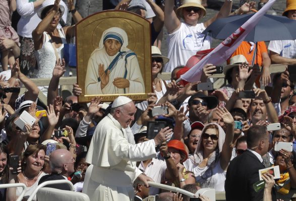 Pope Francis passes in front a portrait of Mother Teresa as he is driven through the crowd at the end of a canonization ceremony in St. Peter's Square at the Vatican, Sunday, Sept. 4, 2016. Francis declared Mother Teresa a saint on Sunday, praising the tiny nun for having taken in society's most unwanted and for having shamed world leaders for the "crimes of poverty they themselves created." (AP Photo/Alessandra Tarantino)