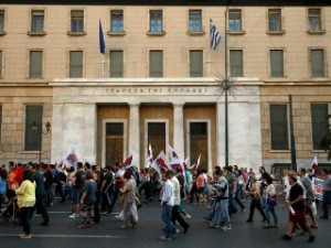 Anëtarë me pikëpamje komuniste të unionit të punës PAME kalojnë përpara bankës greke gjatë një proteste kundër kursimit në Athinë, 23 qershor 2015. Foto: Daniel Ochoa de Olza/AP