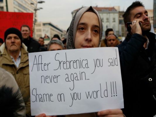Një grua tregon solidaritet me viktimat e Alepos me një pankartë ku shkruhet: "Pas Srebrenicës ju thatë 'kurrë më'. Turp botë!". Foto: Beta/AP/Amel Emric.