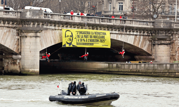 Banderola e varur në një urë mbi Senë që i kujton presidentit Francois Hollande premtimin elektoral për reduktimin e varësisë së Francës nga energjia bërthamore. (AP Photo/Remy de la Mauviniere)