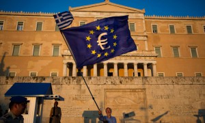 Një demonstrues po valëvit një flamur të Bashkimit Europian para parlamentit të Greqisë më 9 korrik 2015 në mbështetje të masave shtrënguese dhe ruajtjes së anëtarësisë së këtij vendi në euro. (AP Photo/Emilio Morenatti)