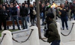 Një protestues i maskuar hedh një bombë molotov kundër policisë më 4 shkurt 2016 në qendër të Athinës. (AP Photo/Petros Giannakouris) 