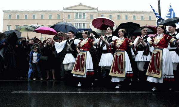Kërcimtarë me kostume popullore të Greqisë pas paradës ushtarake në shesin para parlamentit të Greqisë në Athinë me rastin e ditës së Pavarësisë së vendit nga Perandoria Osmane më 25 mars 2015. (AP Photo/Panayiotis Tzamaros)