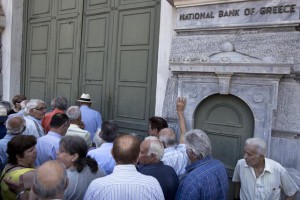 Pensionistët po presin në rradhë më 29 qershor 2015 për të tërhequr pensionin e muajit në selinë qëndrore të Bankës Kombëtare të Greqisë. Qeveria ka njoftuar se do të mbajë bankat të hapura vetëm për të shpërndarë pensionet ndërsa qytetarët mund të tërheqin nga llogaritë e tyre përmes bankomateve jo më shumë se 60 euro në ditë. (AP Photo/Petros Giannakouris)