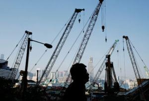 Një njeri po ecën pranë një kantieri ndërtimi në Hong Kong më 1 dhjetor 2016. (AP Photo/Vincent Yu)