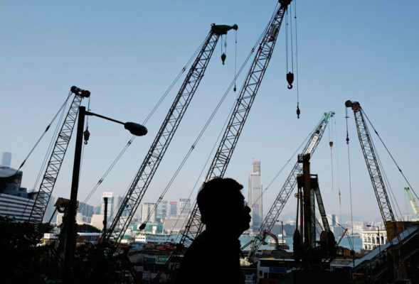 Një njeri po ecën pranë një kantieri ndërtimi në Hong Kong më 1 dhjetor 2016. (AP Photo/Vincent Yu)