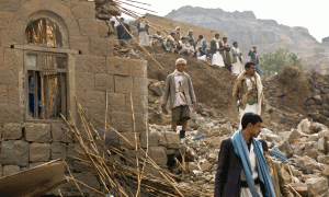 Civilë të Jemenit mbi rrënojat e një shtëpie të shkatërruar nga bombardimet saudite pranë kryeqytetit Sanaa më 4 prill 2015. Jemeni konsiderohet si një viktimë e rivalitetit të fuqive të rajonit për primatin e botës arabe apo islamike. (AP Photo/Hani Mohammed)