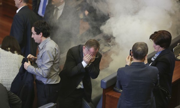 Deputetët e opozitës nën efektin e gazit lotsjellës që u lëshua prej tyre në Kuvendin e Kosovës më 19 shkurt 2016 në Prishtinë. Opozita kërkon dorëheqjen e koalicionit qeverisës Mustafa-Thaçi. (AP Photo/Visar Kryeziu)