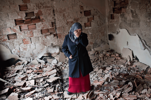 Habibe Biyali brenda një dhome të shtëpisë së saj të shkatërruar nga luftimet në Kumanovë më 11 maj 2015. (AP Photo/Marko Drobnjakovic)