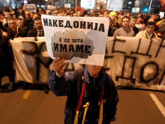 Një burrë mban një poster ku shkruhet “Maqedonia është gjithçka kemi” gjatë një marshimi kundër pranimit të kërkesave të shqiptarëve. Foto: Boris Grdanoski/AP/Beta 
