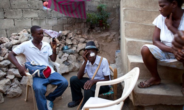 Në këtë foto të 17 gushtit 2015, Mathieux Saint Fleur, 75 vjeç, po pushon në shtëpinë e tij bashkë me të birin, Jackilo Joseph, majtas dhe kushëririn e tij pas një ndërhyrjeje kirurgjikale në syrin e tij të majtë të kryer në Cap-Haitien, Haiti. Operacioni për të u krye nga kandidati republikan për president në SHBA Rand Paul, një okulist nga profesioni i cili kreu një vizitë vullnetarizmi në Haiti bashkë me mjekë të tjerë me synimin për të trajnuar mjekët vendës dhe për të ndihmuar në trajtimin e verbërisë së kurueshme. (AP Photo/Dieu Nalio Chery)