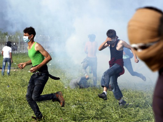 Refugjatët vrapojnë nga gazi lotsjellës i policisë Maqedonase në kufirin Greqi-Maqedoni. Foto: Beta/(AP Photo/Amel Emric)