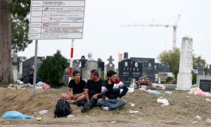 Refugjatët po presin në një varrezë serbe në tokën neutrale në pikën kufitare Sid mes Serbisë dhe Kroacisë më 24 shtator 2015. Tensionet janë rritur mes dy vendeve për shkak të krizës së refugjatëve që po kalojnë në Ballkan në udhëtimin e tyre drejt Europës Perëndimore. (AP Photo/Darko Vojinovic)