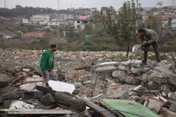 Alban dhe Shkëlqim Sollaku, duke mbledhur hekur skrap në rrënojat e shtëpive të tyre | Foto nga : Gjergj Erebara