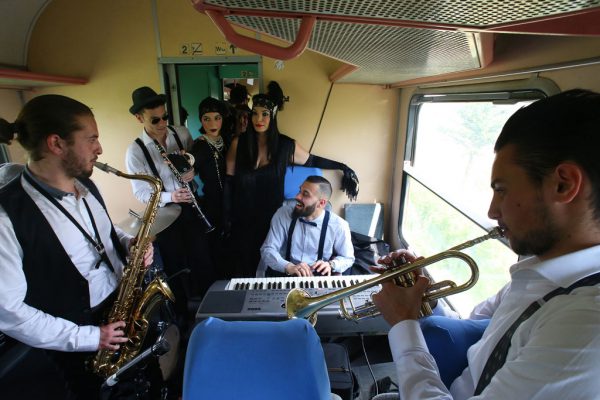 Nga e majta, muzikantët Flavio Sefa, Rajkard Bardh, Mateos Gjipi dhe Roland Gjura luajnë në trenin e 