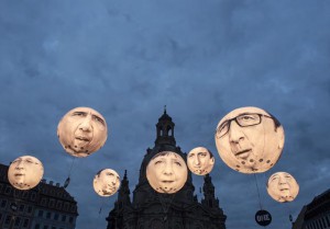 FILE - In this Wednesday, May 27, 2015 file photo, activists of the international campaigning and advocacy organization ONE install illuminated balloons with portraits of the G7 heads of state in front of the Frauenkirche cathedral (Church of Our Lady) prior the G7 Finance Ministers meeting in Dresden, eastern Germany. The G7 Finance Ministers meeting is to be held in Dresden from May 27 to May 29, 2015. (AP Photo/Jens Meyer, File)