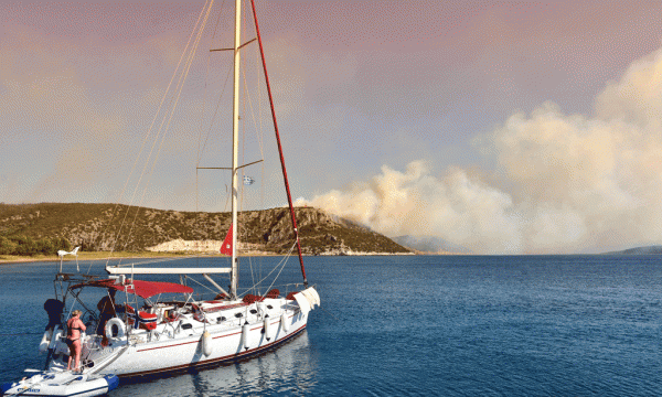 Turistët kanë hipur mbi një varkë ndërsa zjarri po djeg pyjet e malit pranë qytezës Nafplio në jugperëndim të Athinës më 17 korrik 2015. (Vangelis Bougiotis/InTime News via AP) 