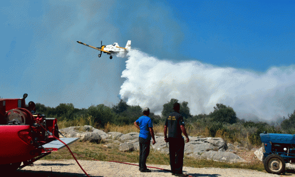 Një avion i vogël po hedh ujë mbi një zjarr pranë fshatit Asini në jugperëndim të Athinës më 20 korrik 2015. (AP Photo/Vangelis Bougiotis)