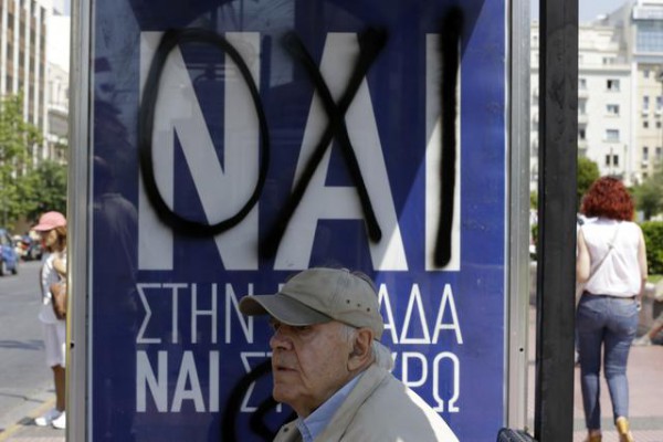 Një i moshuar pret n[ stacion pranë një reklame ku shkruhej fillimisht Po dhe ku është mbishkruar Jo në lidhje me referendumin për borxhin grek këtë të diel. Foto: (AP Photo/Thanassis Stavrakis)