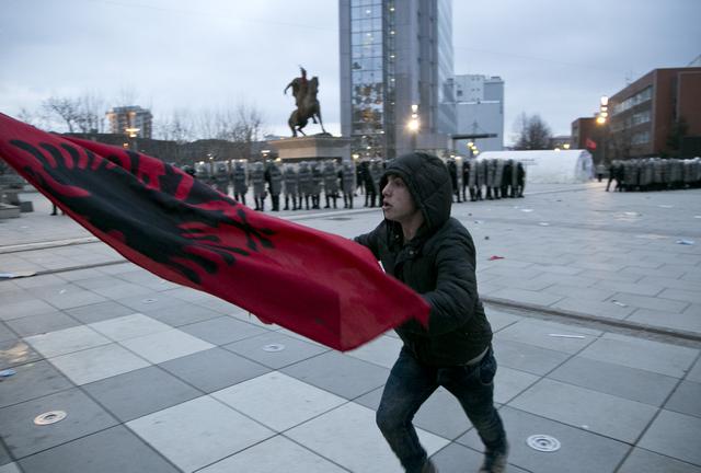 Një protestues me flamurin shqiptar pëpara qeverisë së Kosovës | Foto nga : Visar Kryeziu/AP